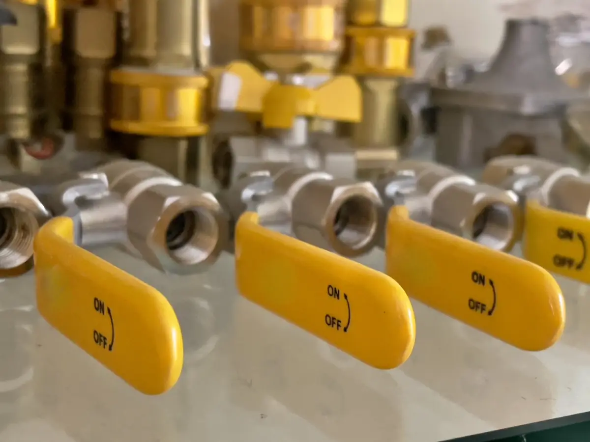 Row of gas ball valves with yellow lever handles · 一排黃色長柄瓦斯球閥