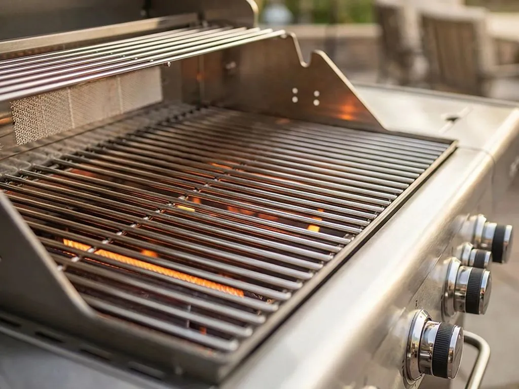 Stainless steel gas grill with cooking grids and burners lit · 點火中的不鏽鋼瓦斯烤爐與烤網